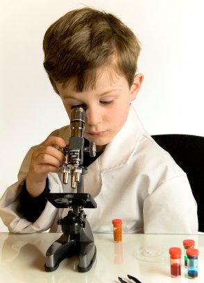 young elementary homeschooler looking through a microscope